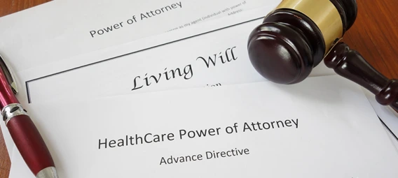 Legal documents including Living Will, Power of Attorney, and Healthcare Power of Attorney with gavel and pen, representing advance healthcare planning and legal preparation.