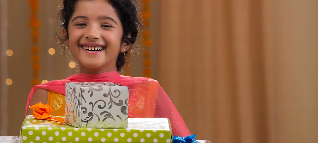 Smiling young person holding stack of colorful wrapped gift boxes, representing gift-giving and special occasions for children