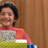 Smiling young person holding stack of colorful wrapped gift boxes, representing gift-giving and special occasions for children
